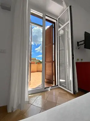 a bedroom with an open door to a balcony at Roma Resort Colosseum in Rome