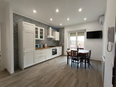 a kitchen with white cabinets and a table and chairs at Casa Vacanze LaMatta Music House in Rome