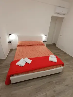 a bedroom with a red bed with towels on it at Casa Vacanze LaMatta Music House in Rome