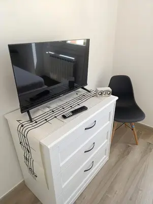 a white dresser with a flat screen tv on top of it at Casa Vacanze LaMatta Music House in Rome