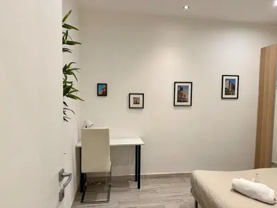a white room with a desk and a bed at Appartamento stazione trastevere in Rome