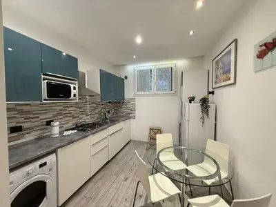 a kitchen with a glass table and a refrigerator at Appartamento stazione trastevere in Rome