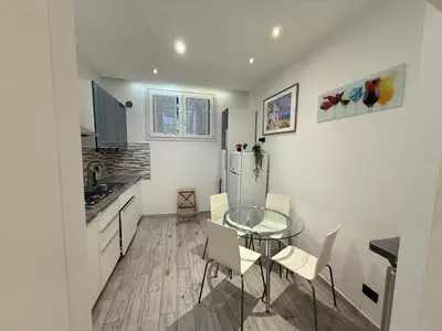 a kitchen with a glass table and a refrigerator at Appartamento stazione trastevere in Rome