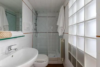 a white bathroom with a sink and a toilet at Trevi Fountain - Modern Suite in 17th-century Palazzo in Rome