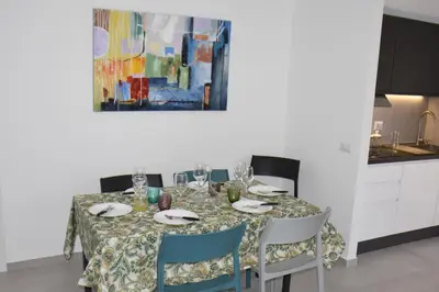 a dining room table with chairs and a painting on the wall at SWEET RETREAT - Trastevere Station in Rome