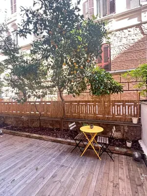 a yellow table next to a tree and a fence at Leonidas house 2 in Rome