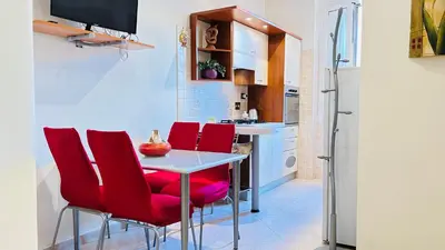a kitchen with red chairs and a table and a refrigerator at Casa Alice in Rome