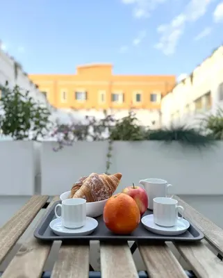 a tray of food with fruit and coffee cups on a table at Labicum XXII - Modern Luxury Studio near the Colosseum in Rome