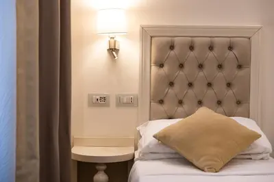 a bedroom with a bed with a headboard and a lamp at Relais Monti in Rome