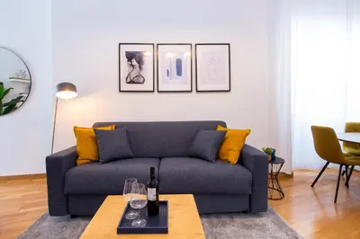 a living room with a blue couch and yellow pillows at Piazza Navona Elegant Apartment in Rome