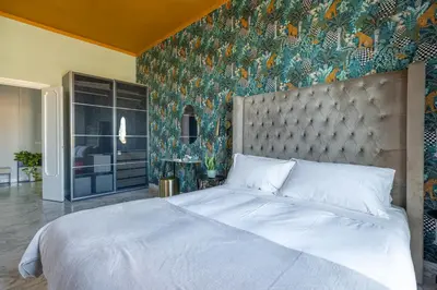 a bedroom with a large bed with a floral wallpaper at Dolce Vita Penthouse in Rome