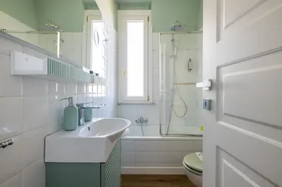 a white bathroom with a sink and a tub at Dolce Vita Penthouse in Rome