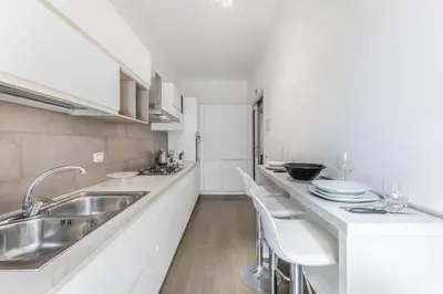a kitchen with a sink and a counter with stools at Casa Malupa Luxury Apts San Giovanni in Laterano in Rome