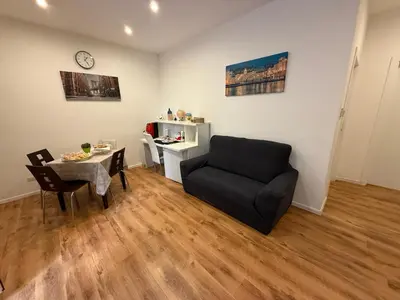 a living room with a black couch and a table at La Dimora di Sara a 10 minuti da Termini in Rome