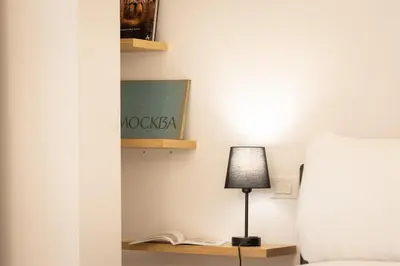 a room with a bed and a lamp on a table at Amazing Via del Corso 277 Suites in Rome