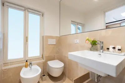 a bathroom with a white sink and a toilet at Amazing Via del Corso 277 Suites in Rome