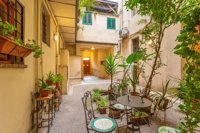 an outdoor patio with tables and chairs and plants at Glam Nest & Garden Colosseum in Rome