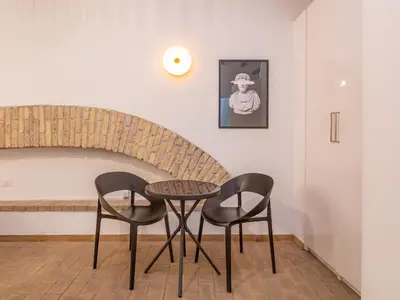 a table and two chairs in a room at Glam Nest & Garden Colosseum in Rome