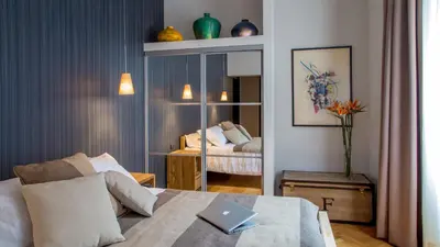 a hotel room with a bed and a mirror at QT Suites Roma in Rome