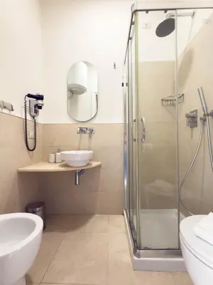 a bathroom with a glass shower and a sink at Colosseum Suites - Zen 22 in Rome