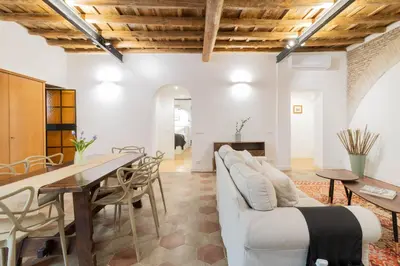 a living room with a white couch and a table at Trilussa Spacious Apartment in Rome