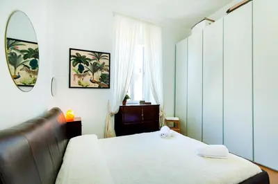 a bedroom with a bed and a mirror and a window at River House in Rome