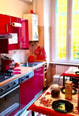 a kitchen with red cabinets and a red counter top at Chez Pierre tourist rental in Rome