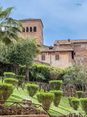 an old building with trees and bushes in front of it at Colosseum suites apartment - Zen 22 in Rome