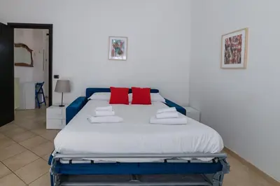 a bedroom with a large bed with red pillows at Pigneto Apartment in Rome