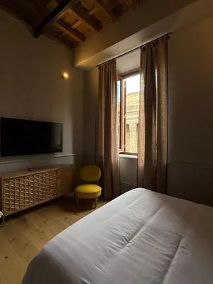 a bedroom with a bed and a tv and a window at Spiriti Home Apartment , New Opening Piazza di Pietra in Rome