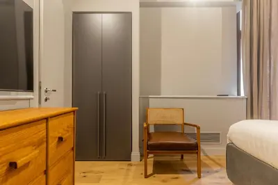 a bedroom with a bed and a chair and a dresser at Spiriti Home Apartment 2, New Opening Piazza di Pietra in Rome
