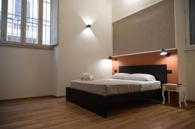 a bedroom with a large bed and a large window at By Lina in Trastevere in Rome