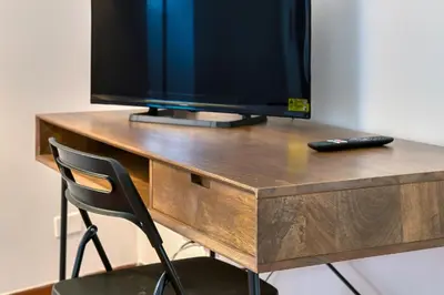 a wooden desk with a television on top of it at Lavinia's Apartment at Colosseo in Rome
