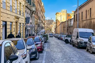 a row of cars parked on a street with buildings at Lavinia's Apartment at Colosseo in Rome
