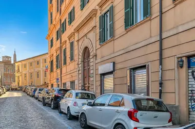 a row of cars parked on a street next to buildings at Lavinia's Apartment at Colosseo in Rome