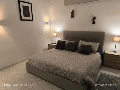 a bedroom with a bed with two night stands and two lamps at Maison Vittoria in Rome