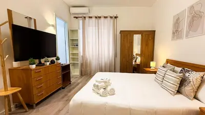 a bedroom with a large bed with a television on it at Elegant Stay a Stone's Throw from Libya Metro in Rome