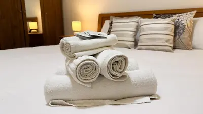 a pile of towels sitting on top of a bed at Elegant Stay a Stone's Throw from Libya Metro in Rome