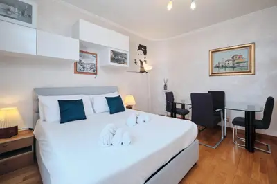 a bedroom with a large white bed and a desk at Metro A 10 minutes - Free Wi-Fi & Netflix in Rome