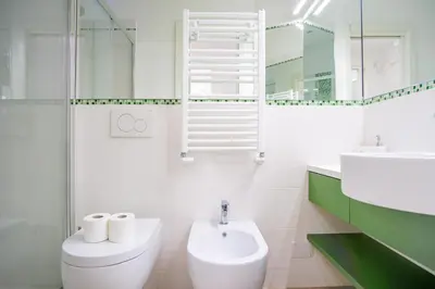 a white bathroom with a toilet and a sink at Elegantis Doris Suite Apartment - One Minute Walk to Vatican Museums in Rome