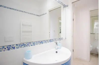 a bathroom with a white sink and a mirror at Elegantis Doris Suite Apartment - One Minute Walk to Vatican Museums in Rome