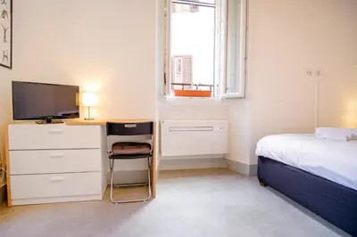 a bedroom with a bed and a desk with a television at Elegantis Trastevere Modern Apartment - Comfort in Rome Most Charming District in Rome