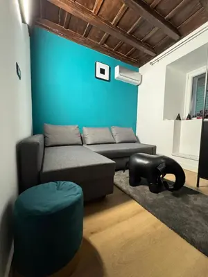 a living room with a couch and a blue wall at Elephant Parliament Apt in Rome
