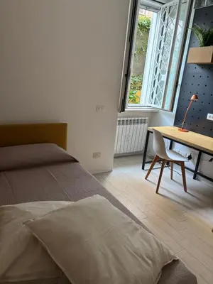 a bedroom with a bed and a desk and a window at da Nonna Dina in Rome