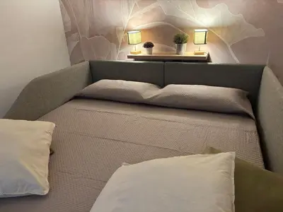 a bed with two pillows and a table with two lamps at da Nonna Dina in Rome