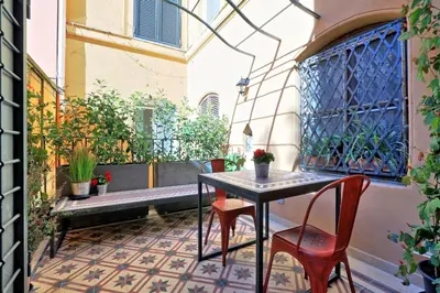 a patio with a table and chairs on a balcony at YCH-Laterano Charme in Rome