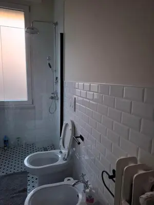 a white bathroom with a toilet and a sink at Appartamento viale Mazzini in Rome