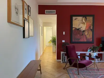 a living room with a table and a red wall at Terme di Tito Colosseum in Rome