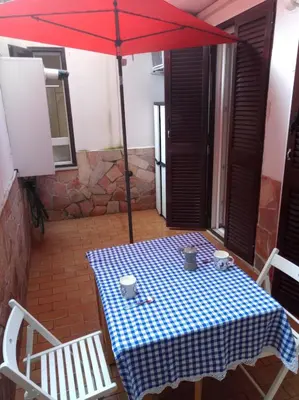 a table with a blue and white checkered table cloth and an umbrella at My Cocoon in Rome