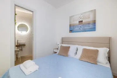 a bedroom with a blue bed and a bathroom at NOSTROMONDO-Elegant Suite with patio in Monti Parioli in Rome